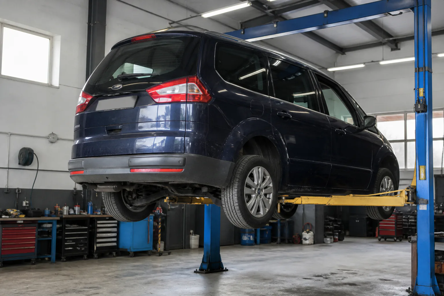 Ford Galaxy на подъёмнике при проверке подвески и тормозов — иллюстрация