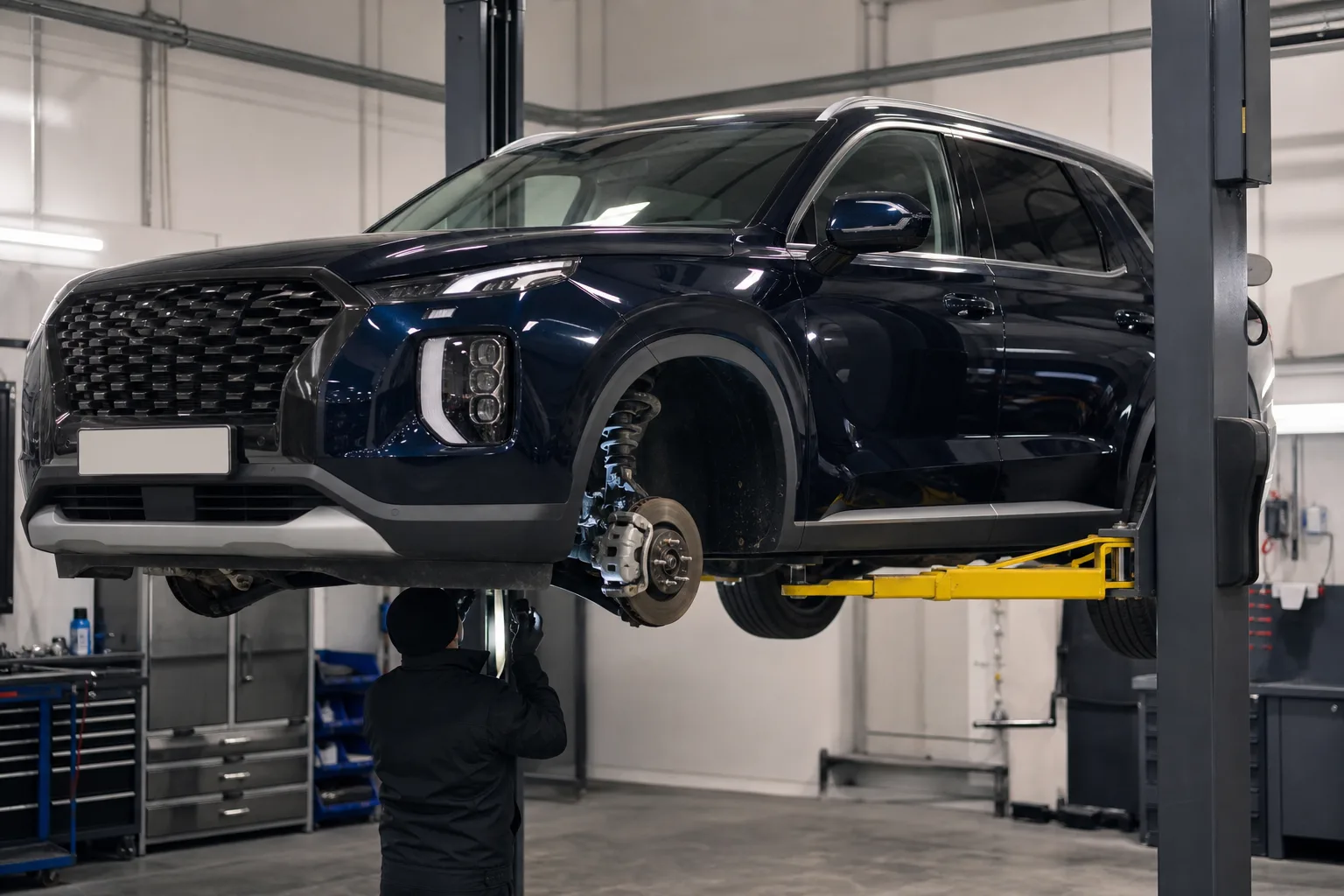 Hyundai Palisade на подъёмнике при осмотре днища и тормозов — иллюстрация
