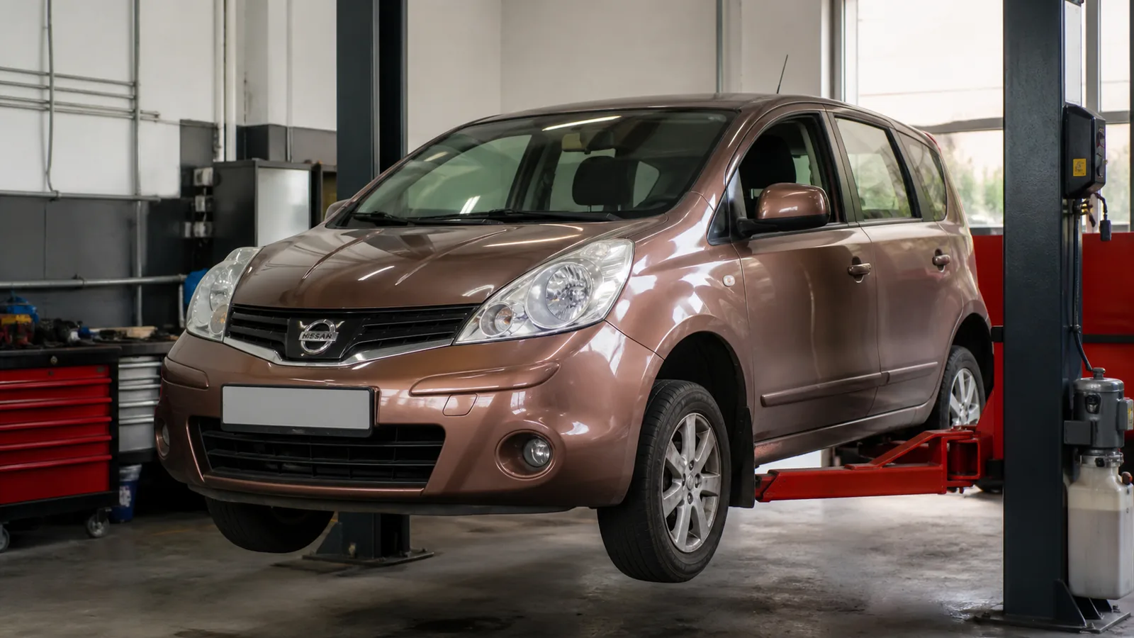 Nissan Note на подъёмнике при осмотре ходовой части — иллюстрация