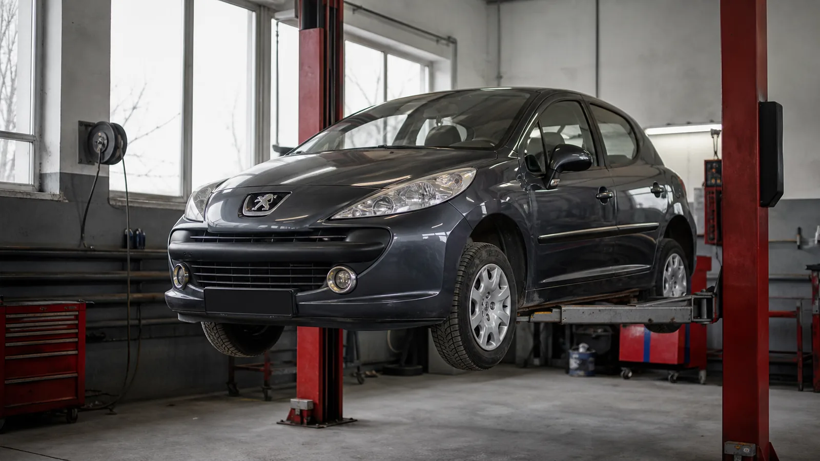 Peugeot 207 на подъёмнике при диагностике ходовой части — иллюстрация