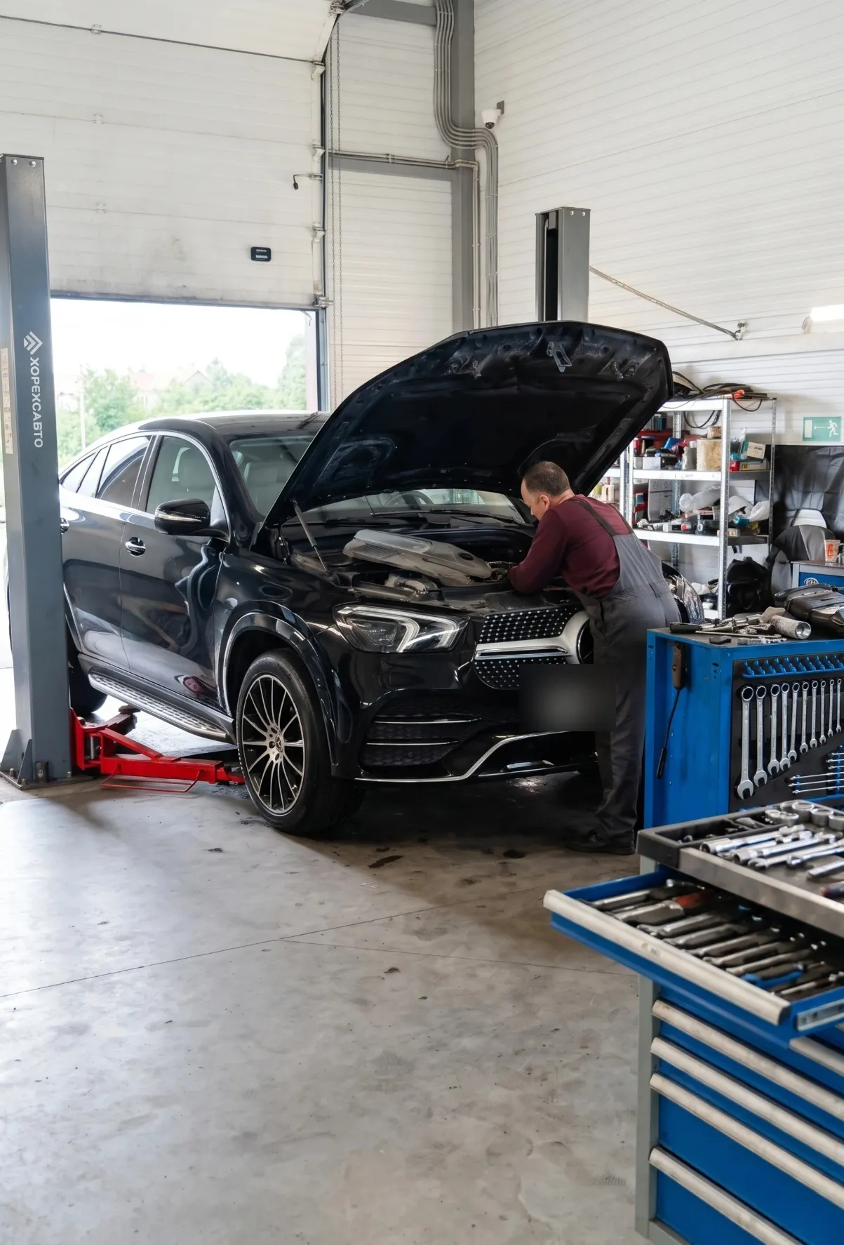Мастер обслуживает двигатель Mercedes-Benz GLE в реальном цехе Ультра Авто